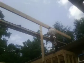 Carpenter setting a ridge beam over a new addition frame — Ice Dam Removal by Roofing Brothers in Cisco