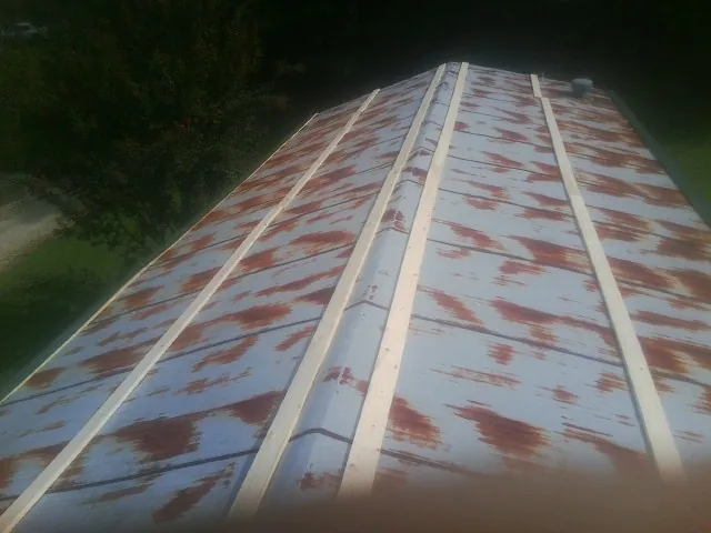 Rusted metal roof panels with new wood purlins before replacement — Storm Damage Roof Repair in Cisco by Roofing Brothers