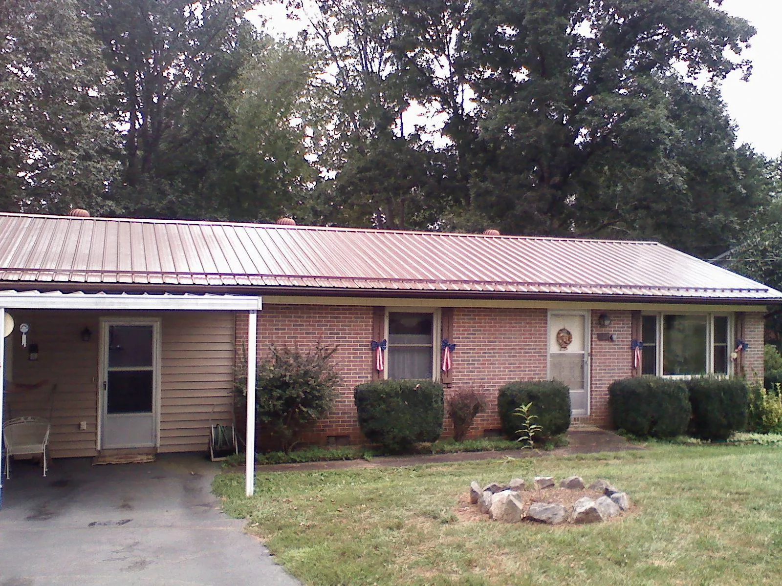 Bronze metal roof and carport on a brick ranch home — Roof Repair work by our crew in Cisco