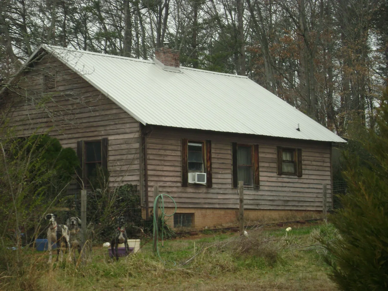 White metal roof on an old wood sided farmhouse, from a Metal Roof Installation job in Cisco